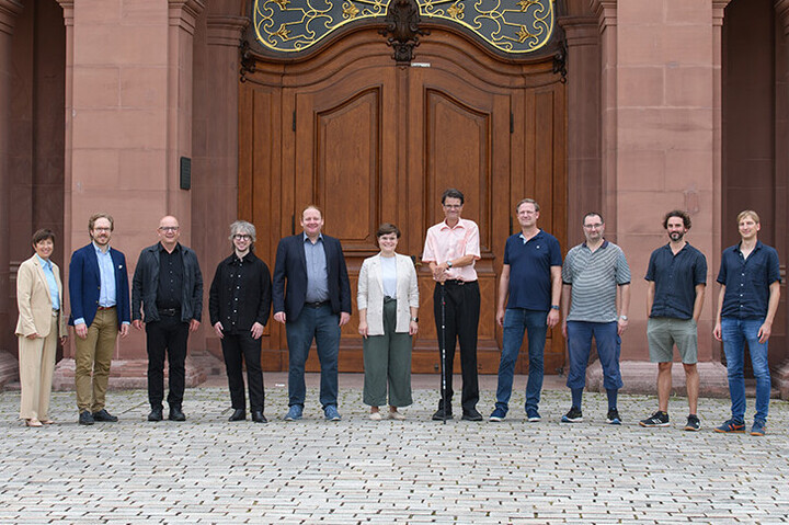 Das Team des Philosophischen Seminars stehen vor dem Eingang zum Mannheimer Rittersaal.