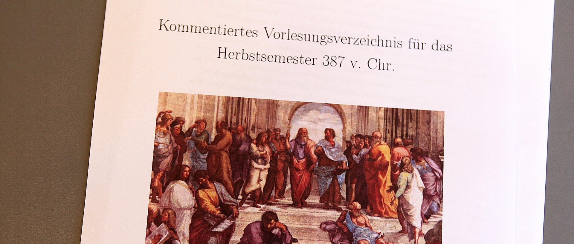 Ausdruck mit einem Bild von gezeichneten Personen mit römischen Gewändern auf einer Marmortreppe vor einem Torbogen mit Überschrift "Kommentiertes Vorlesungsverzeichnis für das Herbstsemester 387 v. Chr."